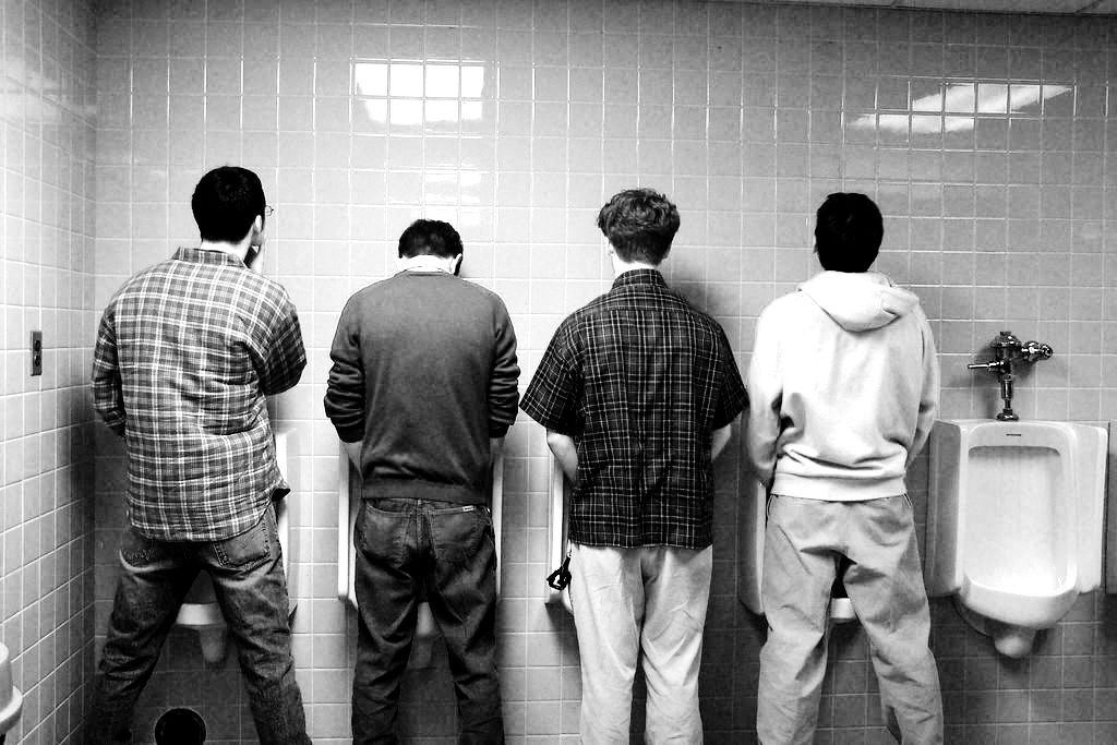 Black guys at the urinal pissing two young